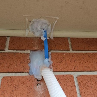 Valley Air Conditioning - Thornton, NSW. Oversize holes cut into brick and eave. Prior to re-work, hole in eave was packed with a plastic rubbish bag