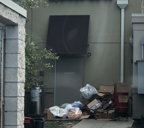 Chipotle Mexican Grill - Kansas City, MO. Pile of trash and boxes at the door right by the bin