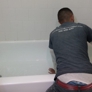 Seattle Bathtub Guy. The technician beginning his work - notice the terrible pre-existing caulking and the large chipped areas at the outside corners
