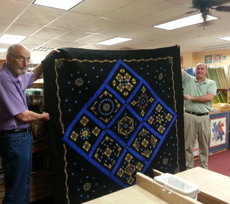 Austin Sewing Machines & Quilts - Round Rock, TX. Bob and Mike with an award winning quilt